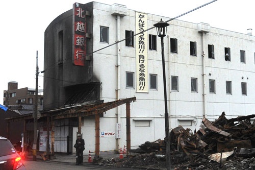 いち早く掲示された「がんばろう！」の垂れ幕。東日本大震災でも熊本地震でも同じバナーを数多く見てきたが……。（写真・山根一眞）