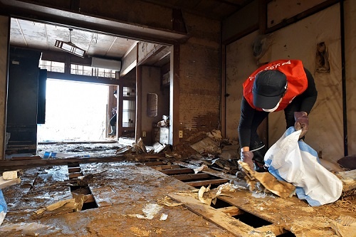 西日本を襲った記録的豪雨で被災した岡山県の民家を掃除するボランティア（写真：UPI/アフロ）