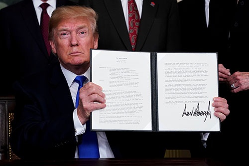 米ホワイトハウスで3月22日、中国製品の輸入に関税の制裁措置をかける大統領令に署名したトランプ大統領（写真：ロイター/アフロ）