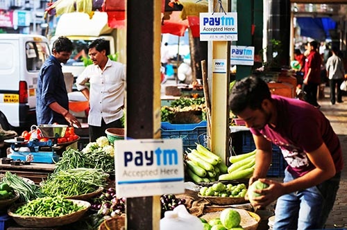 ムンバイの野菜販売店に貼り付けられた「paytm（ペイティーエム）」のボードは、インドのモバイル決済最大手Paytmがサービスを提供する、スマホでの電子決済が可能な店の目印。専用アプリをダウンロードすれば、スマホで手軽に代金を支払うことができる。（写真：ロイター/アフロ）