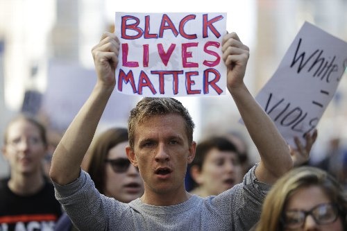 「Black Lives Matter」の標語を掲げる青年（写真：AP/アフロ）