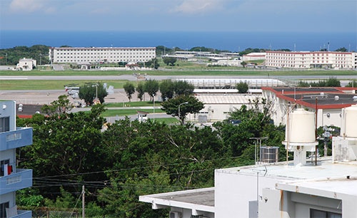 沖縄国際大学から見た普天間基地。木の陰には垂直離着陸輸送機オスプレイも見える。