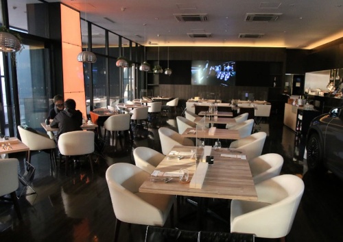 広々とした2階レストラン。白と黒のコントラストが印象的だ。テーブルにはそれぞれアクリル板を設置。サーキュレーターで空気循環も行う