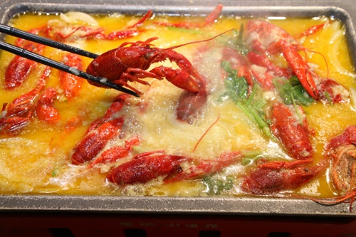 「ザリガニの黄金ニンニク煮込み」。スープで煮込んでいくうちに、ザリガニが鮮やかな赤色にゆであがっていく