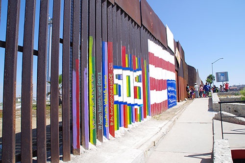 メキシコと米国の間にある国境。カラフルだが「SOS」と書かれている(写真:Guillermo Alonso提供)