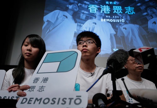 「デモシスト」の結党を発表する黄之鋒（ジョシュア・ウォン）氏（写真中央）（写真：AP/アフロ）