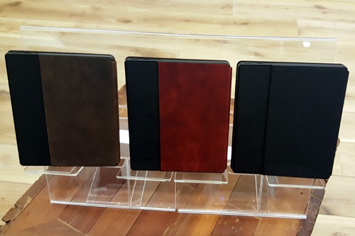 Kindle Oasisのカバー色のバリエーションは3色。左から順に、「ウォルナット（茶）」「メルロー（赤）」「ブラック（黒）」。価格は、広告表示付きのWi-Fiモデルが3万5980円、広告表示なしのWi-Fiモデルが3万7980円、広告表示付きの無料3Gモデルが4万1190円、広告表示なしの3Gモデルが4万3190円（ともに税込み）