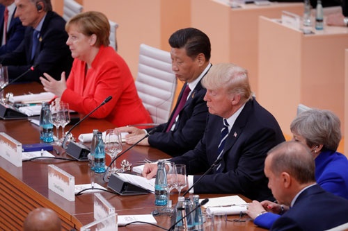 ハンブルクG20でメルケル議長の隣に席を並べた習近平主席とトランプ大統領だが、それぞれの狙いには埋めがたい違いが…(写真:ロイター/アフロ)