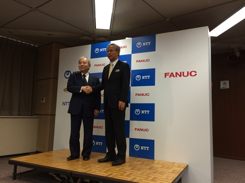 NTTの篠原弘道副社長と握手するファナックの稲葉善治会長（左）