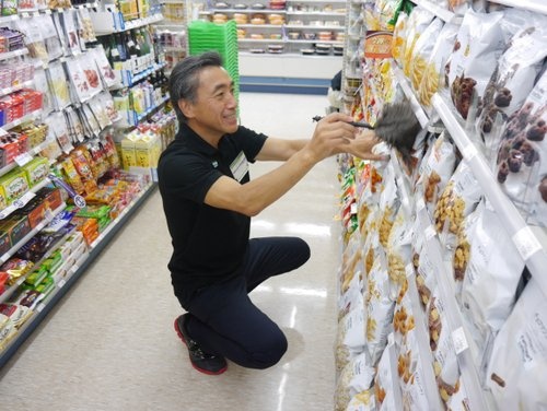今年7月、都内のファミリーマート店舗でスタッフ研修を受ける沢田社長。「レジに立つのは怖かった」