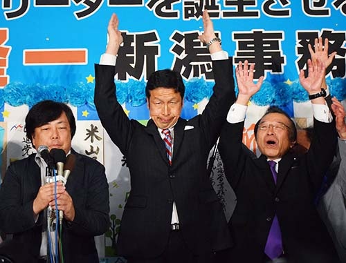 新潟県知事選で勝利し、万歳する米山隆一氏（中央）。10月16日夜、新潟市（写真：時事）