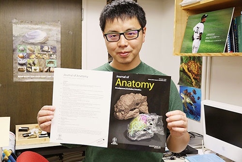 自分の論文の画像が使われた表紙を手にする宮下哲人さん。(写真提供:川端裕人)