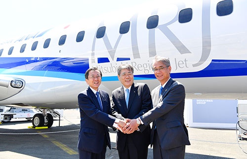 パリ航空ショーで展示されたANA塗装をまとったMRJの前で握手を交わす三菱重工の宮永社長(中央)と三菱航空機の水谷社長(右)、ANAホールディングスの篠辺副会長