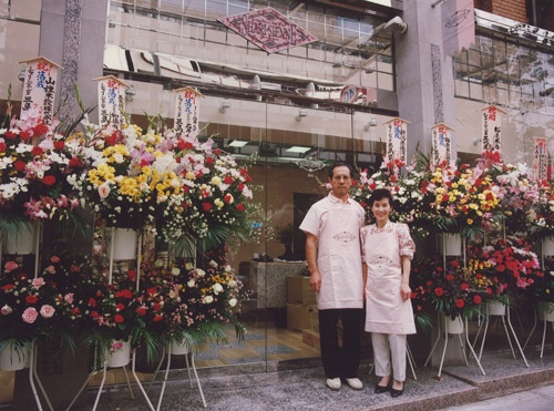 新保圭司郎さんと妻のまさみさん。1989年、改装したばかりの三島屋の前で(東京都新宿区)
