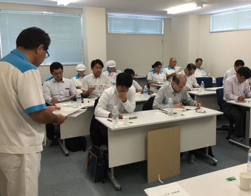 国産米とカルローズの比較検査で説明を受ける審査員たち(日本炊飯協会提供)