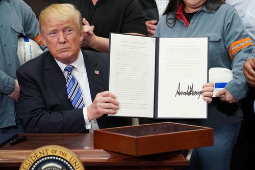 3月8日に大統領令に署名したトランプ大統領(写真:AFP/アフロ)