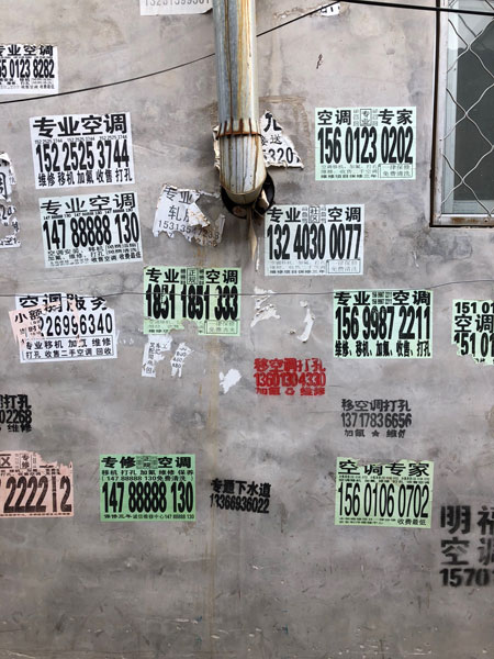 エアコン設置・修理のチラシだらけの壁（新建村）