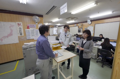 群協製作所ではL字型オフィスの角に社長席と打ち合わせ席がある。どちらも立ち席で周囲がよく見え、遠山社長(左)は社員の働きぶりに気を配る(写真:新関雅士)