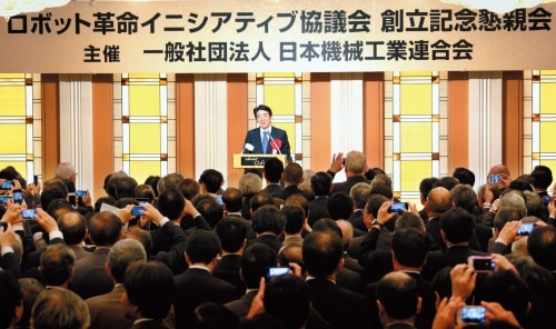 5月に行われた「ロボット革命イニシアティブ協議会」の創立記念懇親会で安倍晋三首相は「日本発のロボット革命を起こす」と意気込んだ（写真＝共同通信）