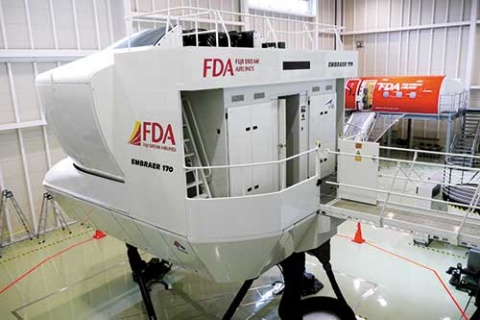 <b>国内唯一となるエンブラエル機のフライトシミュレーター。奥に見えるのは、脱出訓練などを行うモックアップ。この設備のために約20億円を投資をした</b>