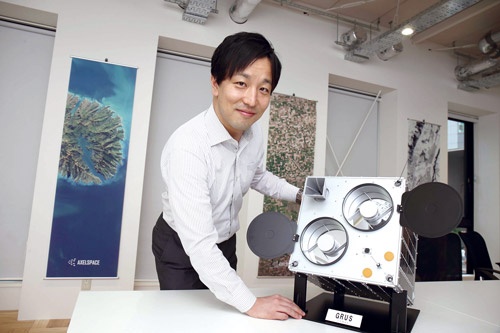 <b>50基の小型衛星が連携</b><br>衛星「GRUS」を2022年までに50基打ち上げる。1日1回、地球上の人間が活動する全領域の観測が可能になる。左は中村友哉CEO(写真=都築 雅人)