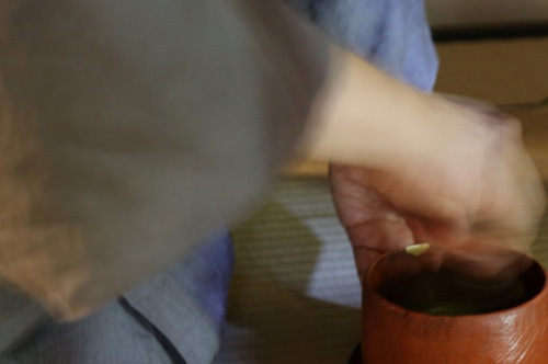 左手で茶碗が支えられ、茶筅で点てられる