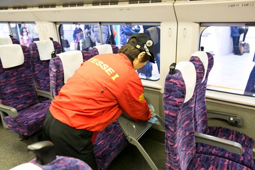 様々な道具を使って効率的に掃除するテッセイの姿を見ようと足を止める乗降客も多い