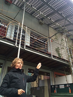 自宅の屋根に設置した太陽光パネルを示しながら資産価値について説明するマイヤーさん