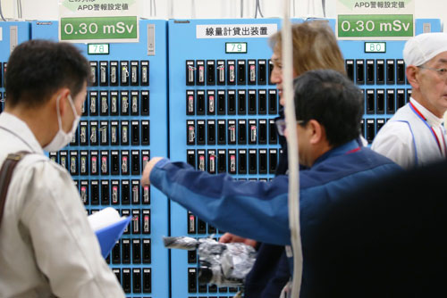 APD（警報付き個人線量計）の貸し出し装置と作業員（写真：日本記者クラブ取材団代表撮影）