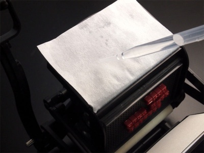 インキ台に付属の吸い取り紙をセットし、スポイトで水滴を垂らしてインキ台に吸い取り紙を貼り付ける