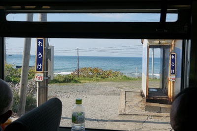 礼受駅に停車すると、ホームから日本海がきれいに望めた。右側に写っている駅舎は古い貨車を改造したもの。
