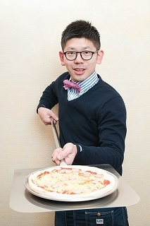 東京・合羽橋の調理道具専門店「飯田屋」の6代目、飯田結太氏。飯田氏が持っている巨大なピザピール（ピザサーバー）は長さ130cm。ピザ職人の定番アイテムだ