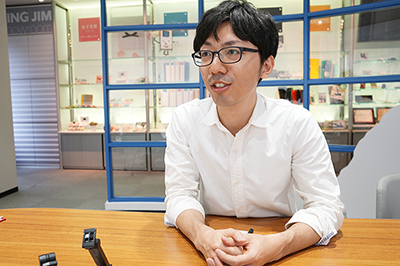 キングジム開発本部商品開発部開発二課の木次谷氏。ガラス天板を採用することで人気が出た机上台「デスクボード」の開発も担当
