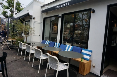 施設内の両側、2棟に分かれているピッツェリア＆カフェ「アップマーケット ピッツァ＆カフェ」。全195席（店内115席 / テラス80席）。営業時間は月～土が11～14時半（ラスト・オーダー、以下同）、17時半～22時、カフェタイムが11時～22時半。日曜・祝日は11～14時半、17時半～21時、カフェタイムが11～21時半。無休