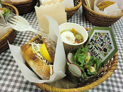 新商品の「たっぷり国産キャベツのメンチ」（292円）と「いつもと違う！フライ用4種の添え野菜」（376円）を挟んだハンバーガー（写真左）、週に1500食以上売れているという「たっぷりケールのチーズナッツサラダ」（637円、写真手前）、「彩り野菜と玉子の入ったごちそうスープ」（616円、写真奥）