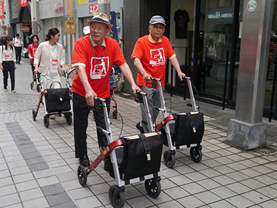 街歩きイベント「タブレット付きまちなかカートを使ってまちなかゆる歩き！！」の様子。参加者はまちなかカートを使って商店街を歩く