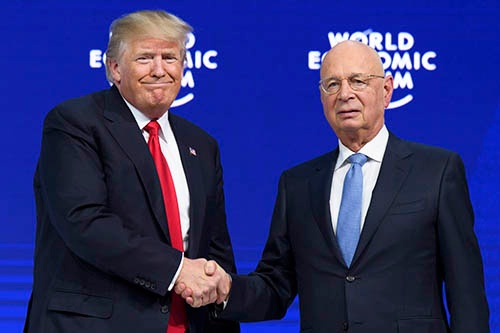 ダボス会議を運営する世界経済フォーラムのクラウス・シュワブ会長(右)と握手をするドナルド・トランプ米大統領。(写真:AP/アフロ)