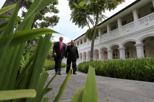 6月12日、昼食前に並んで散策するドナルド・トランプ米大統領と北朝鮮の金大恩委員長(写真:ロイターアフロ)
