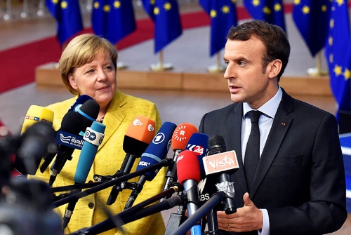 ドイツのメルケル首相(左)とフランスのマクロン大統領は、ベルギーのブリュッセルで開かれたEU首脳会議において14日、共同記者会見を行った。(写真:ロイター/アフロ)
