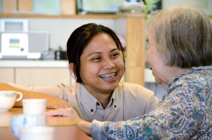 <span class="fontBold">入居者の女性と話す東南アジア出身の介護福祉士</span>（写真=朝日新聞社）