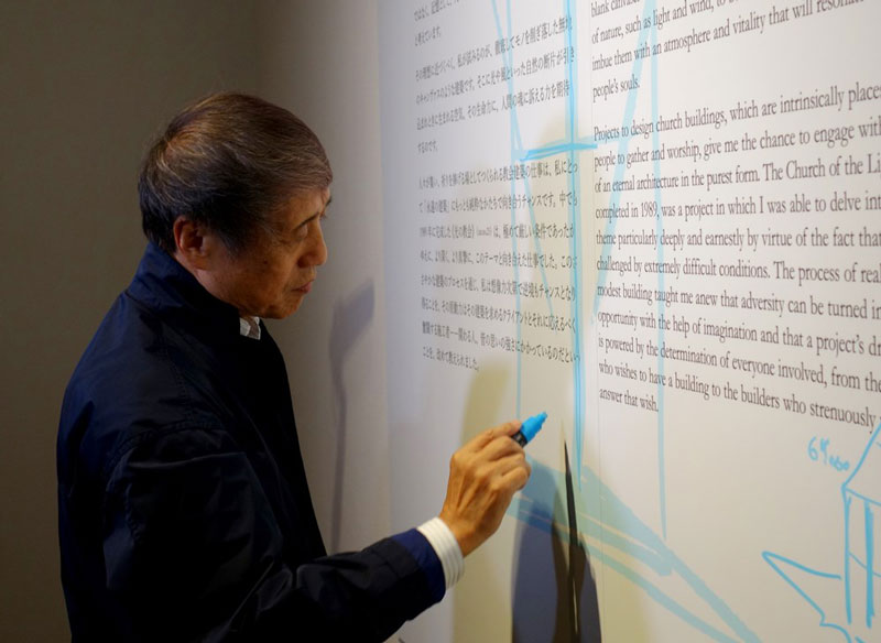 国立新美術館の安藤忠雄展の会場で、白く空いたスペースを埋めるために、突然スケッチを描き始めた安藤氏（写真：日経アーキテクチュア）