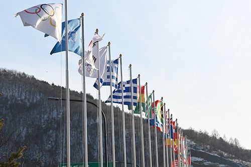 世界的なスポーツ、中でもオリンピックは民衆の愛国心を激しく喚起する。昔から政治的な駆け引きの大舞台としても利用されてきた。（写真は韓国・平昌の冬季五輪会場に掲げられた万国旗、JMPA代表撮影（佐貫 直哉） ）