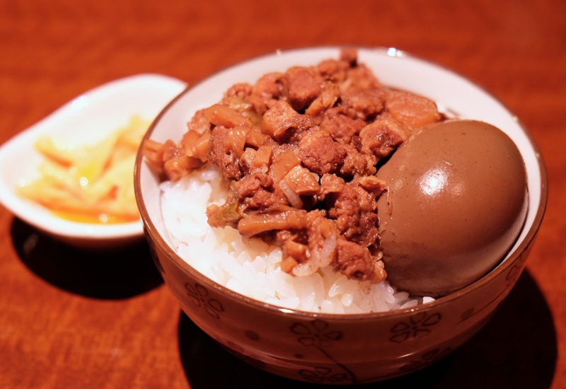 台灣物産館の魯肉飯。魯肉飯には漬け物が添えてあることが多く、また、煮卵のトッピングもポピュラーとか
