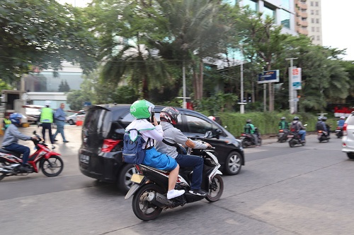 ライドシェア・配車サービスは東南アジアで市民の足として定着している(写真はインドネシアのグラブのドライバーと利用者)