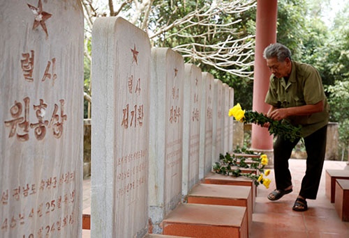 ベトナム戦争に参加し、戦士した北朝鮮兵の墓に詣でるベトナム人の元兵士（写真：ロイター/アフロ）
