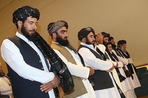 米国との和平協定への署名に臨んで、祈りをささげるタリバンの代表団（写真：AP/アフロ）
