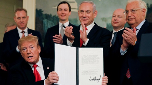 ゴラン高原に関するイスラエルの主権を承認する文書に署名するトランプ大統領(左)。中央に立つのはイスラエルのネタニヤフ首相。その左後方はトランプ大統領の娘婿のクシュナー氏。政権の中東外交のカギを握る親イスラエル派(写真:ロイター/アフロ)