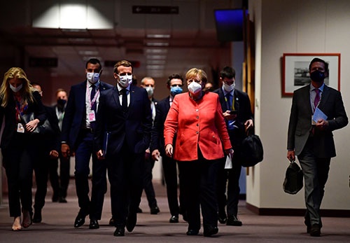 EU首脳会議を終え記者会見に向かうメルケル独首相(右)とマクロン仏大統領(左)(写真:代表撮影/ロイター/アフロ)