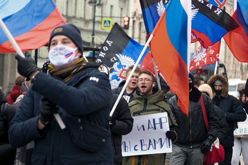 ロシアによる独立承認を歓迎する親ロ派の活動家や学生。ロシアとドネツク人民共和国の旗をたなびかせる（写真：AP/アフロ）