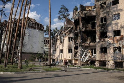 ロシアのウクライナ侵攻後すぐにウクライナ支援に動いた欧米諸国の結束が試練に直面している。戦争が始まって3カ月が経過した今、この先の方針を巡って足並みの乱れが見えるからだ。写真はキーウ近郊イルピンで9日、破壊された建物を見る人（2022年　ロイター／Marko Djurica）